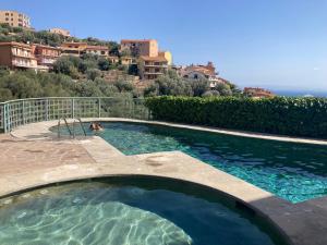 a swimming pool with a person in the water at Super Terrace in Porto Santo Stefano
