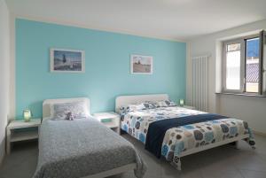 1 dormitorio con paredes azules, 1 cama y 1 silla en Chery Bed & Breakfast, en Riva San Vitale