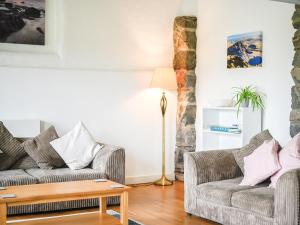 a living room with two couches and a table at Awel Deg in Arthog