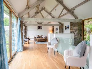 a living room with wooden flooring and large windows at Awel Deg in Arthog