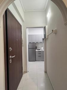 a hallway with a door leading to a kitchen at Miranda's Apartment Koukaki in Athens