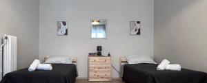 a room with two beds and a dresser and a window at Miranda's Apartment Koukaki in Athens