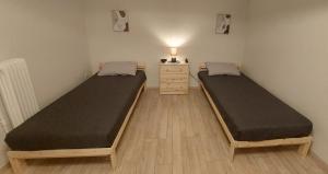 two beds in a small room with a dresser and a bed at Miranda's Apartment Koukaki in Athens