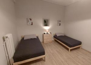 a bedroom with two beds and a dresser with a lamp at Miranda's Apartment Koukaki in Athens