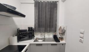 a small kitchen with a sink and a window at Miranda's Apartment Koukaki in Athens +16 photos
