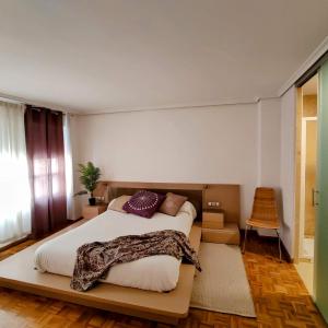 ein Schlafzimmer mit einem großen Bett mit lila Kissen in der Unterkunft Atico céntrico espectacular y cerca de la playa in Castellón de la Plana