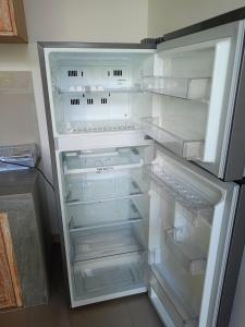 un réfrigérateur vide avec sa porte ouverte dans une cuisine dans l'établissement Pulmo Residen Canggu, à Canggu