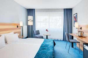 a hotel room with a bed and a desk at IntercityHotel Frankfurt Airport Terminal 3 in Frankfurt +24 photos