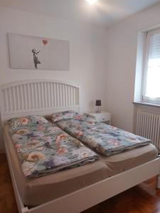 a bed in a bedroom with a bedspread on it at A casa di Cato in Merano