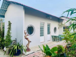 a white house with plants in front of it at Ben Tre Inn in Xóm Kính