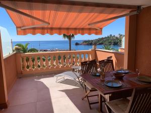 a table on a balcony with a view of the ocean at Plage de Miramar in Théoule-sur-Mer