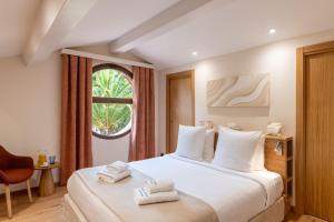 a hotel room with a bed with towels on it at Les Maisons Du Sud in Saint-Tropez