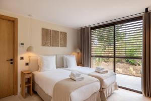 a bedroom with two beds and a large window at Les Maisons Du Sud in Saint-Tropez