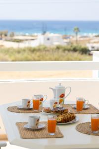 een tafel met een ontbijt van thee en jus d'orange bij Villa Porto Rondo in Agios Prokopios