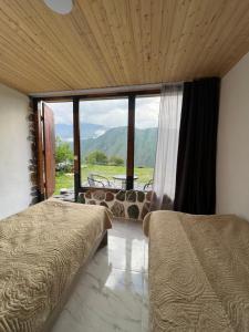 una camera da letto con due letti e una grande finestra di Ardoti Inn a Ardoti