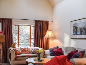 a living room with a couch and a table at Gushat Cottage in Strathtay