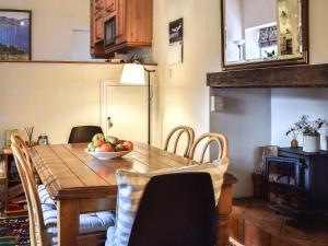 a dining room table with a bowl of fruit on it at Gushat Cottage in Strathtay