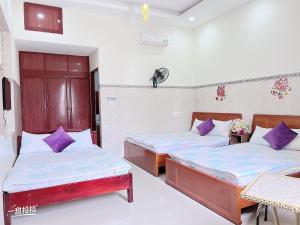 two beds in a room with purple pillows at Nhà nghỉ 72 in Long Hai +7 photos