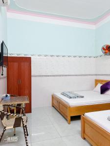a room with two beds and a chair in it at Nhà nghỉ 72 in Long Hai +7 photos