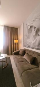 a living room with a large couch and a table at CENTRAL CHIC APARTAMENT with SPA and GYM in Bucharest +22 photos