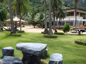 a park with a stone bench and a building at Koh Chang Bailan Beach Resort in Ko Chang