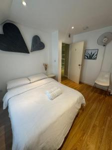 ein Schlafzimmer mit einem großen weißen Bett mit zwei Herzen an der Wand in der Unterkunft Sleep 8 In the heart of Central London Hy4 in London