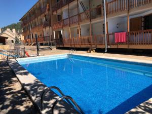a large blue swimming pool in front of a building at Salamandra Panticosa in Panticosa
