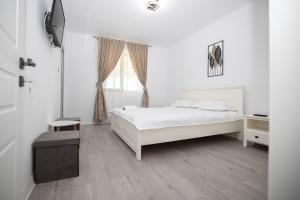 a white bedroom with a bed and a window at Rem Garden in Novaci +10 photos
