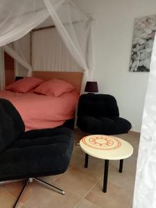 une chambre avec un lit, deux chaises et une table dans l'établissement petite maison avec jardin calme, au Thor