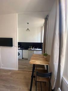 a small kitchen with a wooden table and a dining room at Les Arches in Saintes