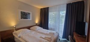 a hotel room with a bed and a window at BusinessHotel Am Peetzsee Grünheide in Schlangenluch +35 photos