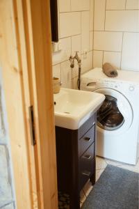 a bathroom with a sink and a washing machine at Widokowe Domki Kościelisko in Kościelisko +116 photos