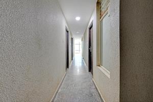 a hallway with white walls and a long hallway at Hotel O PMR Hotel in Bengaluru