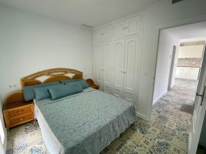 a bedroom with a bed with blue pillows on it at Casa Susana in La Azohía