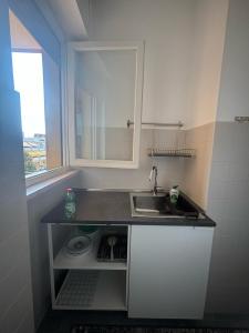 una piccola cucina con un lavandino e una finestra di Al mare da Ersy a Montesilvano Altre 14 foto