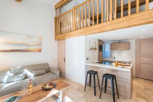 a kitchen and living room with a couch and a table at Les Maisons Du Sud in Saint-Tropez