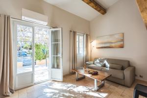 a living room with a couch and a table at Les Maisons Du Sud in Saint-Tropez