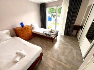 una camera da letto con due letti, una sedia e una finestra di Villa T5 jardin au pays basque a Urcuit