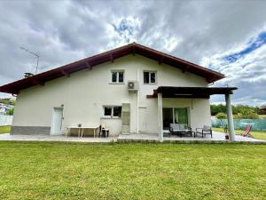 una casa bianca con un patio e un prato di Villa T5 jardin au pays basque a Urcuit