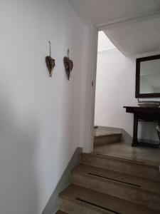 a staircase with two butterflies hanging on the wall at Appartamento Novecento in Enguiso +28 photos