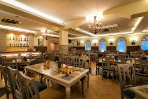 a restaurant with tables and chairs in a room at Cross Roads Inn in Bangalore