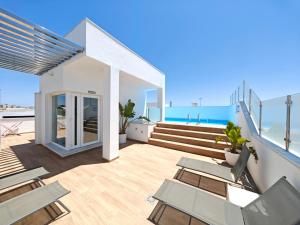 a house with a balcony with chairs and the ocean at Apartamento a estrenar en Planta Primera C con piscina in Barbate