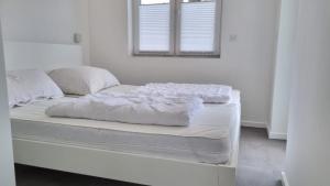a white bed with white sheets and a window at Haus Landliebe in Gremersdorf