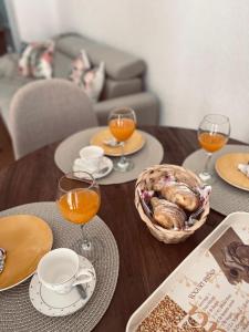 a table with plates of food and glasses of orange juice at Studio apartman Ana in Livno