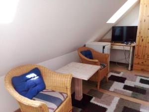 a living room with a table and chairs and a desk at Dworek Łeba in Łeba