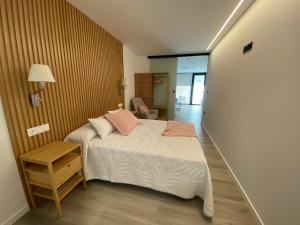 een slaapkamer met een bed met roze kussens erop bij Apartamentos Turísticos Vidal Costa in Foz