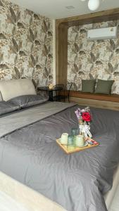 a tray with flowers and candles on a bed at ดาด้าพูลวิลล่า in Ban Pa Ngiu