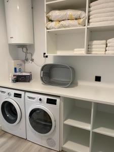 een keuken met een wasmachine en een magnetron bij Apartamentos Turísticos Vidal Costa in Foz