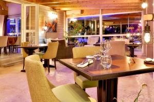 a restaurant with a wooden table and chairs at Logis Hôtel Restaurant Europa in Maussac