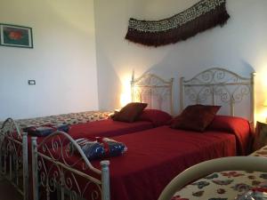 two beds with red sheets in a bedroom at Nido del Salento in Villaggio Resta
